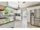 Bright kitchen featuring stainless steel appliances, granite countertops, white cabinets, and ample natural light at 2408 Linsey St, Tampa, FL 33605