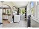 Sunlit laundry room featuring a washing machine, shelving, and access to the kitchen at 2408 Linsey St, Tampa, FL 33605