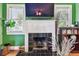 Bright living room featuring a fireplace with a TV mounted above and natural light from the windows at 2408 Linsey St, Tampa, FL 33605