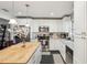 Bright kitchen featuring white cabinets, stainless steel appliances, butcher block island, and modern pendant lighting at 2853 Enisgrove Dr, Palm Harbor, FL 34683