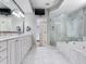 Luxurious primary bathroom featuring marble countertops, dual sinks, walk-in shower, and a soaking tub at 2927 W Bayshore Ct, Tampa, FL 33611
