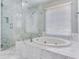 Close up of a marble surround soaking tub and walk-in shower in the primary bathroom at 2927 W Bayshore Ct, Tampa, FL 33611