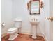 Elegant powder room featuring a pedestal sink with gold fixtures, ornate mirror, and wood flooring at 2927 W Bayshore Ct, Tampa, FL 33611