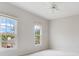 Bright bedroom with two windows offering outdoor views and a ceiling fan at 2927 W Bayshore Ct, Tampa, FL 33611