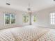 Bright bedroom with multiple windows, ceiling fan, and patterned floral carpeting at 2927 W Bayshore Ct, Tampa, FL 33611