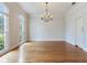 Elegant dining room with a chandelier, hardwood floors, and large windows provides ample lighting at 2927 W Bayshore Ct, Tampa, FL 33611