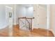 Hallway with wood floors and white railing, leading to rooms with ample natural light at 2927 W Bayshore Ct, Tampa, FL 33611