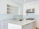 Modern kitchen featuring stainless steel appliances, light blue backsplash, and open shelving at 2927 W Bayshore Ct, Tampa, FL 33611
