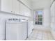 Laundry room with washer, dryer, sink, cabinets and tile floors at 2927 W Bayshore Ct, Tampa, FL 33611
