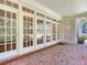 Covered rear patio boasting brick pavers and an array of multi-pane windows providing views into the home at 2927 W Bayshore Ct, Tampa, FL 33611
