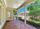 Rear brick patio with a covered overhang and white columns, as well as well-maintained landscaping at 2927 W Bayshore Ct, Tampa, FL 33611