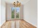 Empty room with wood floors, white trim, and a beautiful chandelier by the french doors at 2927 W Bayshore Ct, Tampa, FL 33611