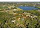 Expansive aerial view of a property, defined by red lines, with mature trees and a nearby lake at 308 N Smokey Mountain Rd, Seffner, FL 33584