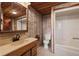 Functional bathroom with vanity, toilet, tub, shower, and patterned wallpaper at 308 N Smokey Mountain Rd, Seffner, FL 33584