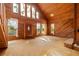 Open-concept living room featuring wood paneling, tall windows, and a vaulted ceiling, providing a warm and inviting space at 308 N Smokey Mountain Rd, Seffner, FL 33584