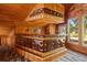 Close up of wet bar area featuring brown leather, wood paneling, stained glass window and overhead lighting at 308 N Smokey Mountain Rd, Seffner, FL 33584