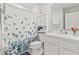 Well-lit bathroom featuring a shower with a leaf-patterned curtain and vanity with storage at 3138 Victoria Inlet Dr, Holiday, FL 34691