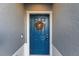 Stylish blue front door adorned with a seasonal wreath, creating a welcoming entryway to the home at 3138 Victoria Inlet Dr, Holiday, FL 34691