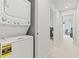 Bright hallway features modern washer/dryer, neutral walls and carpet, with open doorways at 3138 Victoria Inlet Dr, Holiday, FL 34691