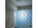 This bathroom features a blue-and-white patterned shower curtain, a sink and a toilet at 3211 E 23Rd Ave, Tampa, FL 33605