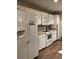 Bright kitchen featuring white appliances and cabinets, paired with wood-look flooring at 3211 E 23Rd Ave, Tampa, FL 33605
