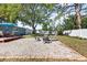 Spacious backyard featuring a gravel fire pit area, patio and lush landscaping at 4105 W Fair Oaks Ave, Tampa, FL 33611
