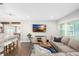 Bright and airy living room featuring a cozy sectional, wood floors, and a view into the modern kitchen at 4105 W Fair Oaks Ave, Tampa, FL 33611