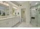 Spacious bathroom with double sink vanity, walk-in glass shower, and neutral tile flooring at 4206 Preserve Pl, Palm Harbor, FL 34685