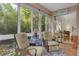 Enclosed lanai featuring comfortable seating and views of the lush surrounding greenery at 4206 Preserve Pl, Palm Harbor, FL 34685