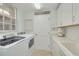 Bright laundry room with modern washer and dryer, ample cabinet space, and a convenient utility sink at 4206 Preserve Pl, Palm Harbor, FL 34685