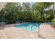 Community pool surrounded by brick pavers, lounge chairs, and lush landscaping, perfect for relaxation and recreation at 4206 Preserve Pl, Palm Harbor, FL 34685