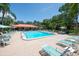 Community pool and clubhouse surrounded by lounge chairs, tables, and lush landscaping at 4910 Bay Ne St # 308, St Petersburg, FL 33703