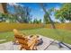 Landscaped backyard includes green lawn, an outdoor fire pit, Adirondack chairs, and wood fence at 4925 Camellia S Way, St Petersburg, FL 33705