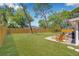 View of the spacious backyard with a fire pit, patio, and plenty of green space at 4925 Camellia S Way, St Petersburg, FL 33705