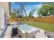 Outdoor living space features a spa, stainless steel grill, green lawn, and wood fence at 4925 Camellia S Way, St Petersburg, FL 33705