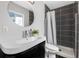 Updated bathroom featuring dark tile in the shower, modern fixtures, and round mirror at 4925 Camellia S Way, St Petersburg, FL 33705
