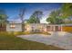 Charming single-story home with modern wood accents, a gravel driveway, and a well-manicured front lawn at 4925 Camellia S Way, St Petersburg, FL 33705