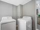Functional laundry room features a washer and dryer, neutral walls and floors, and overhead lighting at 4925 Camellia S Way, St Petersburg, FL 33705