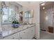Bright bathroom with a granite countertop, stylish vanity, and a tiled walk-in shower at 5 Island Park Pl # 305, Dunedin, FL 34698