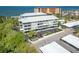 Aerial exterior view of the building with landscaping, a parking area, and a glimpse of the water at 5 Island Park Pl # 305, Dunedin, FL 34698
