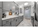 Galley kitchen boasts gray cabinets, stainless steel appliances, and marble countertops and floors at 5 Island Park Pl # 305, Dunedin, FL 34698