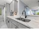 Modern kitchen boasts gray cabinetry, stainless steel appliances, and gleaming marble countertops at 5 Island Park Pl # 305, Dunedin, FL 34698