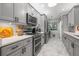 Renovated kitchen with modern gray cabinetry, stainless steel appliances, and marble counters and floors at 5 Island Park Pl # 305, Dunedin, FL 34698