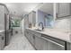 Modern kitchen features sleek gray cabinets, stainless steel appliances, and a stylish marble backsplash at 5 Island Park Pl # 305, Dunedin, FL 34698