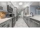 Updated kitchen featuring gray cabinets, stainless steel appliances, and sleek marble countertops at 5 Island Park Pl # 305, Dunedin, FL 34698
