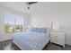 Bedroom has dark wood floors, a large window with blinds, and a white bed covered in a blue and white patterned quilt at 5000 Culbreath Key Way # 8-308, Tampa, FL 33611