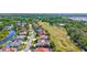 Aerial view highlighting a home nestled in a golf community with mature trees and a picturesque pond at 5137 Epping Ln, Zephyrhills, FL 33541