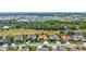 Expansive aerial view showcases the neighborhood with green golf course and pond, featuring the home with a pool at 5137 Epping Ln, Zephyrhills, FL 33541