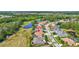 An aerial view shows the home nestled between the golf course and a neighborhood with mature trees at 5137 Epping Ln, Zephyrhills, FL 33541