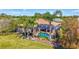 Beautiful backyard featuring a screened-in pool with mature palm trees, and a lush green lawn at 5137 Epping Ln, Zephyrhills, FL 33541